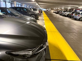 Photo of Many parked cars in underground garage of apartment complex