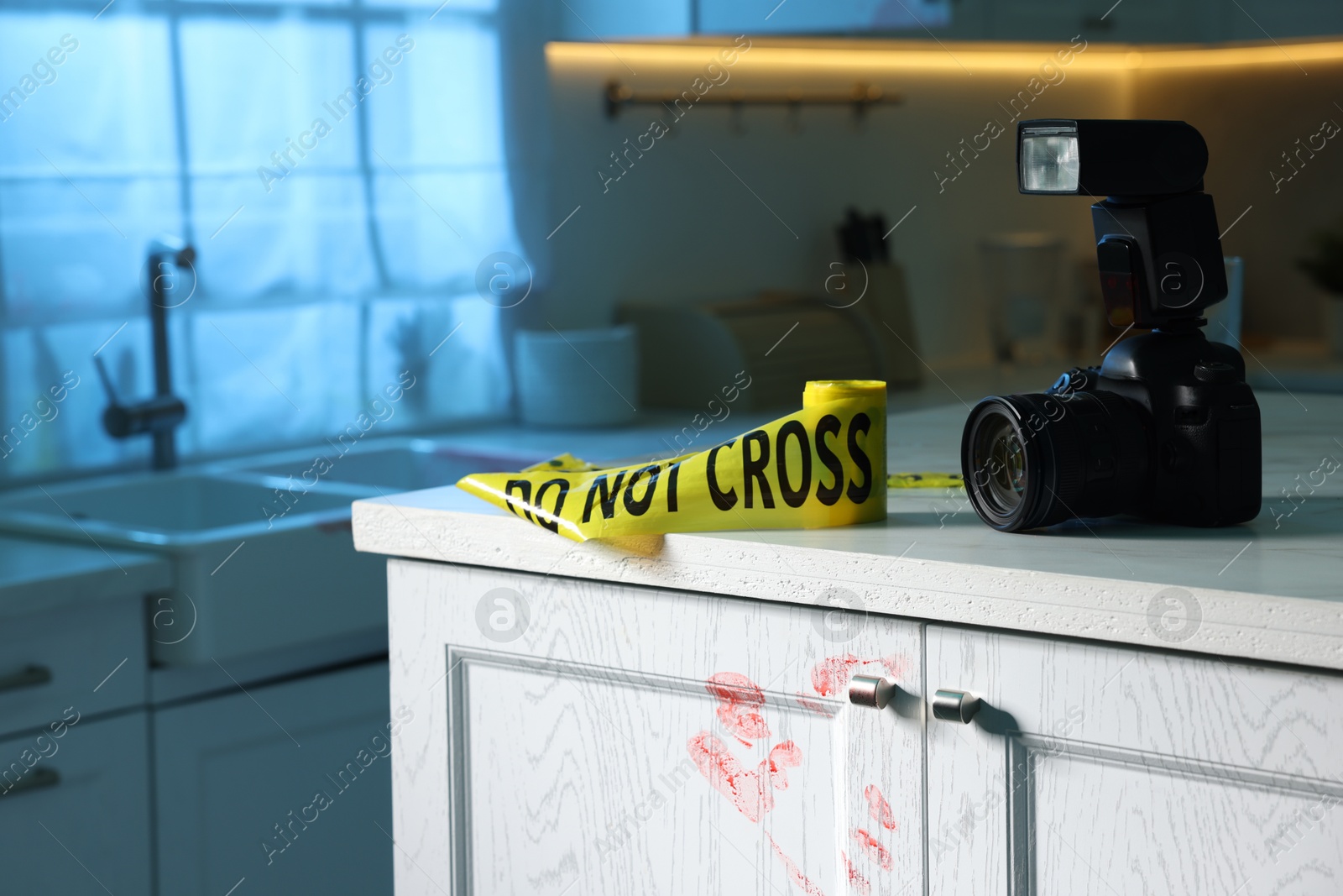 Photo of Camera, yellow crime scene tape and bloody handprint on chest of drawers in kitchen. Forensic expertise