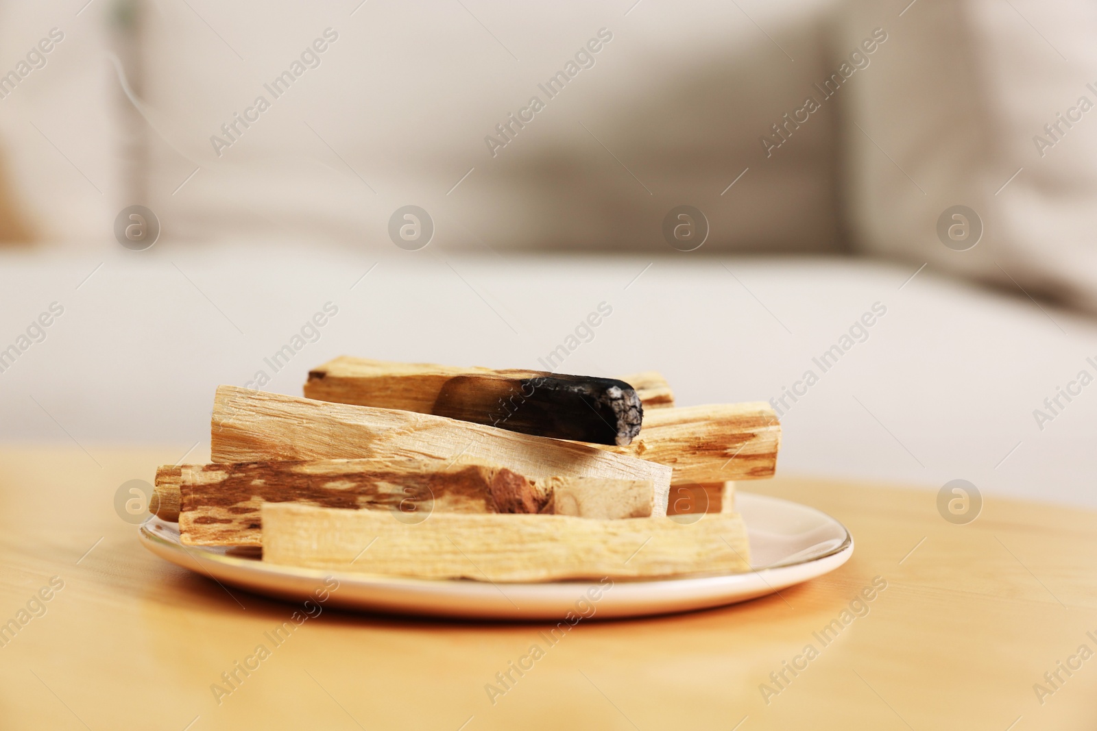 Photo of Palo santo sticks and burnt one on table indoors