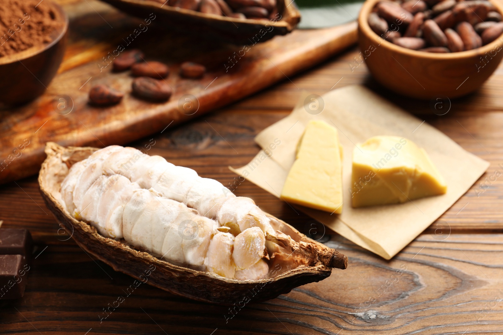 Cocoa pod with beans and butter on wooden table, closeup Photo of Cocoa pod with beans and butter on wooden table, closeup