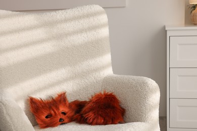 Photo of Quadrobics. Fox mask, gloves and tail on armchair indoors