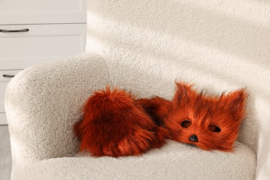 Photo of Quadrobics. Fox mask, gloves and tail on armchair indoors