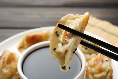 Eating fried gyoza dumplings at wooden table, closeup