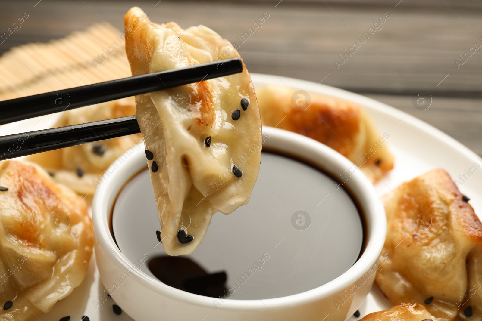 Photo of Eating fried gyoza dumplings at wooden table, closeup