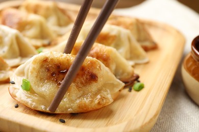 Photo of Eating fried gyoza dumplings at table, closeup