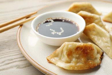 Delicious fried gyoza dumplings served on wooden table, closeup