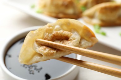 Eating fried gyoza dumplings at white table, closeup