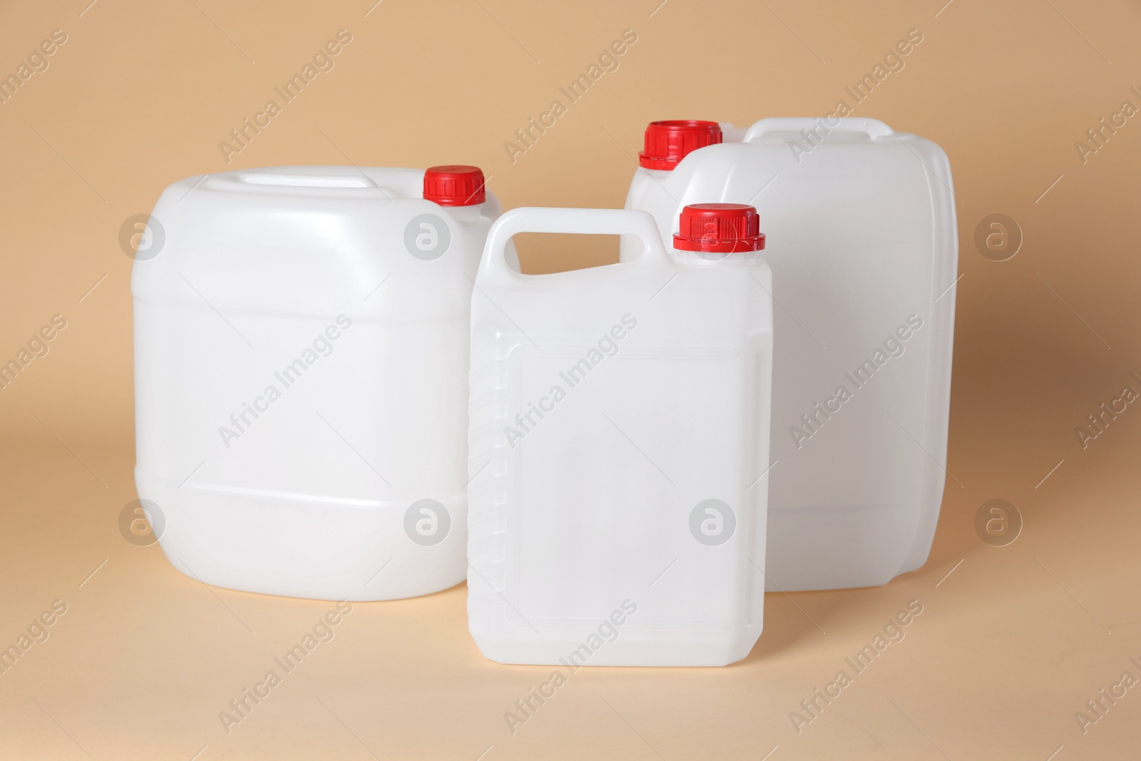 Photo of Many white plastic canisters on beige background