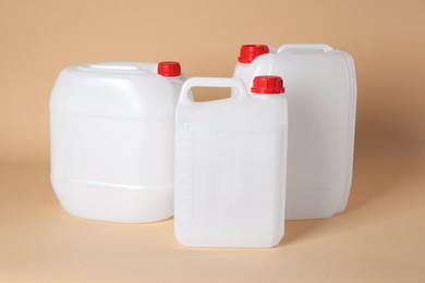 Photo of Many white plastic canisters on beige background