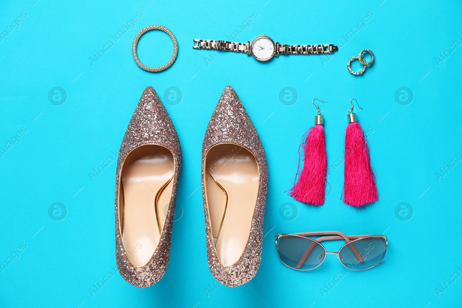 Photo of Beautiful high heeled shoes and stylish accessories on light blue background, flat lay