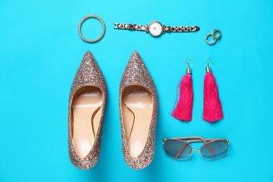 Photo of Beautiful high heeled shoes and stylish accessories on light blue background, flat lay