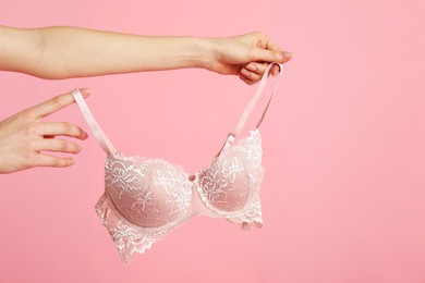 Photo of Woman with lace bra on pink background, closeup. Space for text