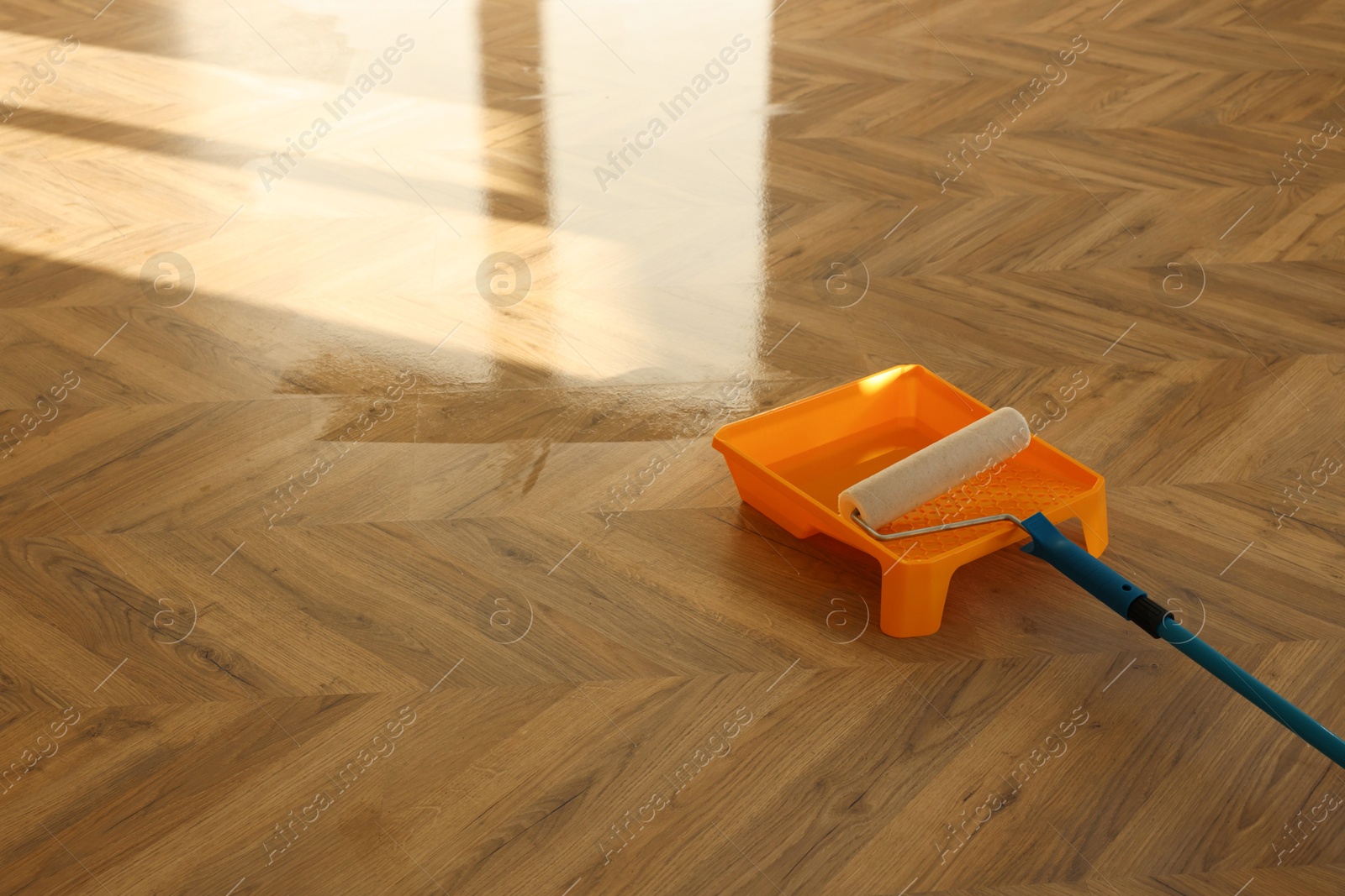 Photo of Process of polishing. Roller and tray with varnish on floor, space for text