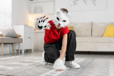 Photo of Quadrobics. Boy wearing cat mask and gloves at home