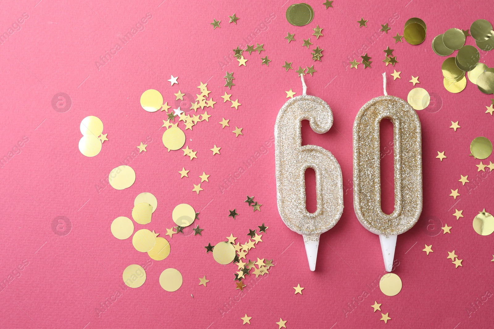 Photo of 60th birthday. Number shaped candles and confetti on pink background, flat lay. Space for text