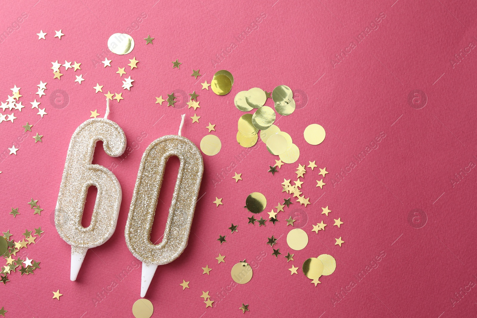 Photo of 60th birthday. Number shaped candles and confetti on pink background, flat lay. Space for text