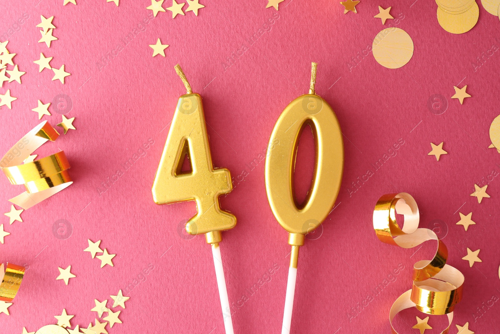 Photo of 40th birthday. Number shaped candles and confetti on pink background, flat lay