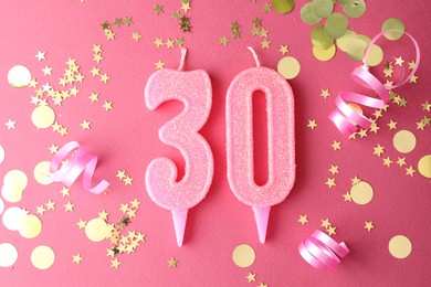 Photo of 30th birthday. Number shaped candles and confetti on pink background, flat lay