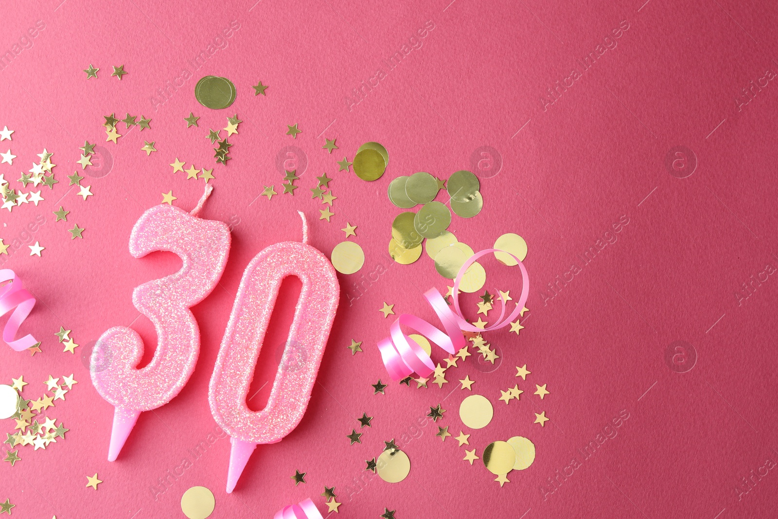 Photo of 30th birthday. Number shaped candles and confetti on pink background, flat lay. Space for text