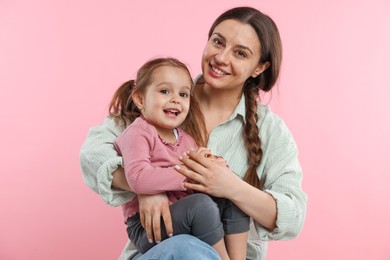 Photo of Portrait of mother with her cute daughter on pink background