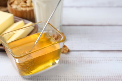 Photo of Sweet honey, butter and milk on white wooden table, closeup. Space for text