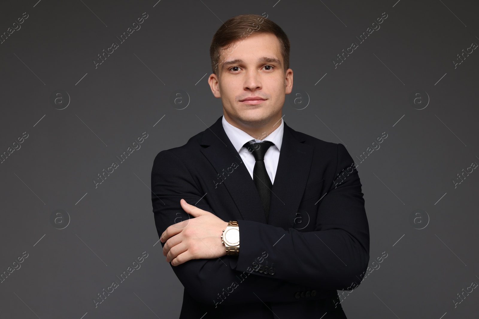 Photo of Man in classic suit with stylish watch on grey background