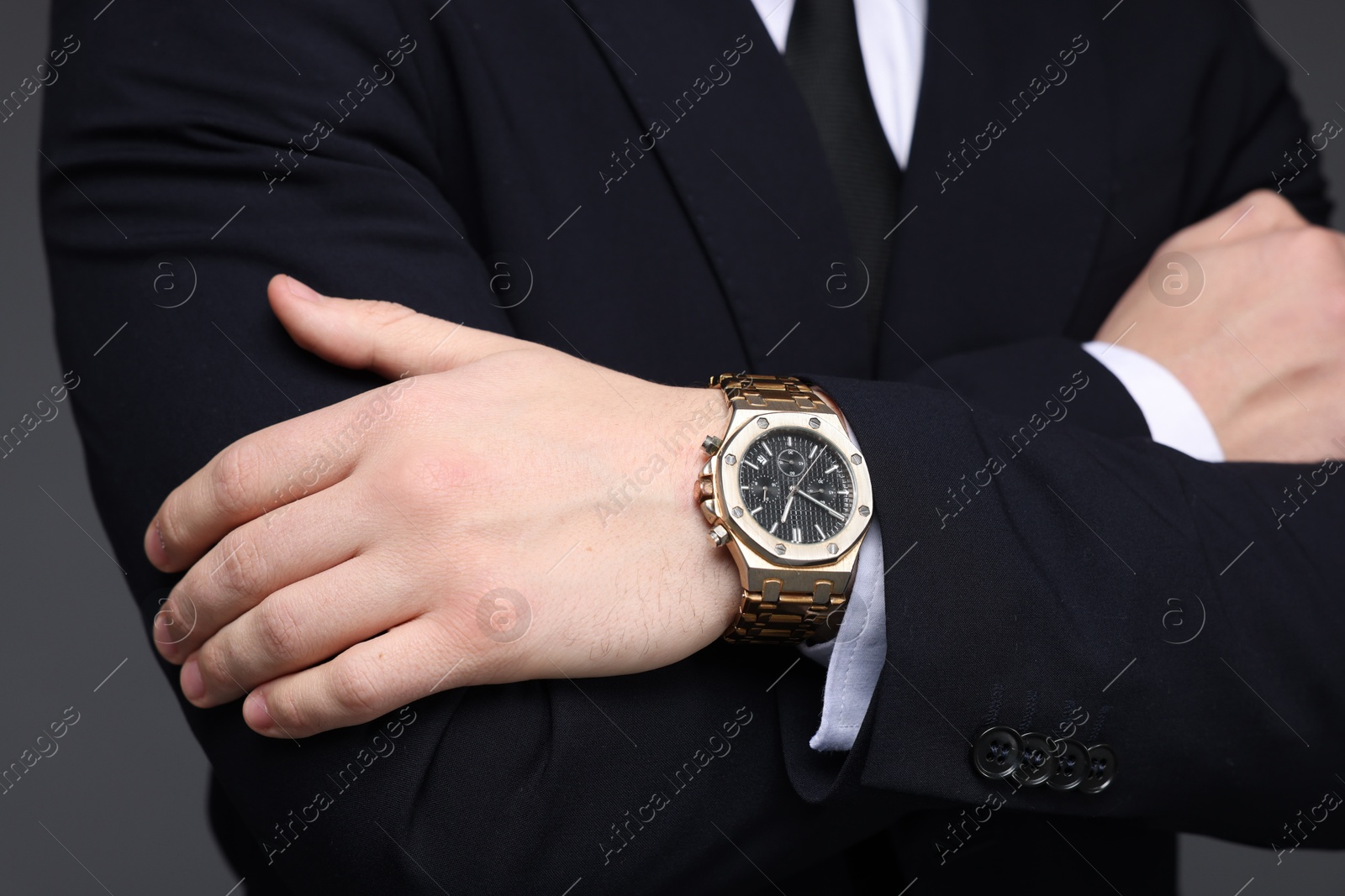 Photo of Man in classic suit with stylish watch on grey background, closeup