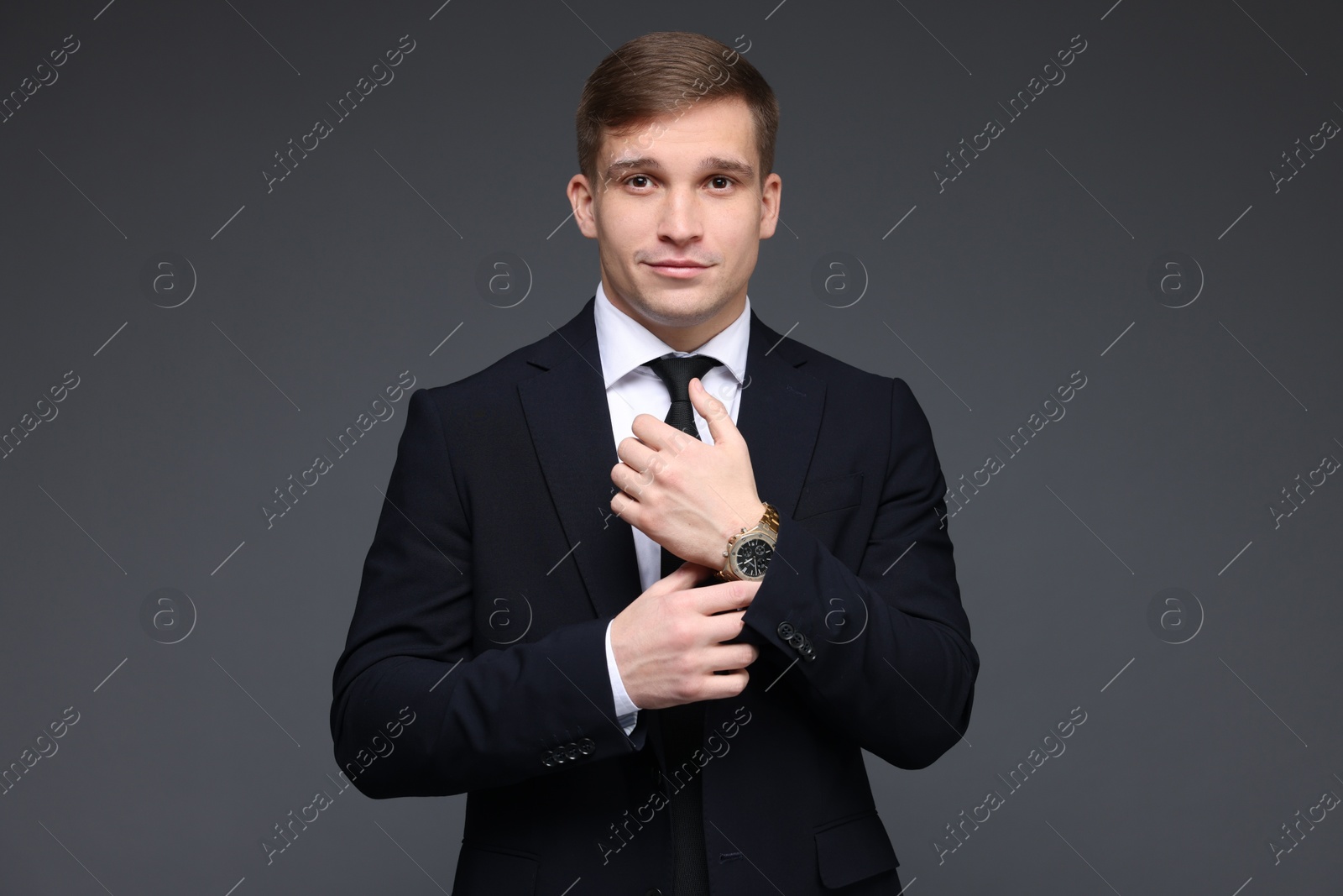 Photo of Man in classic suit with stylish watch on grey background