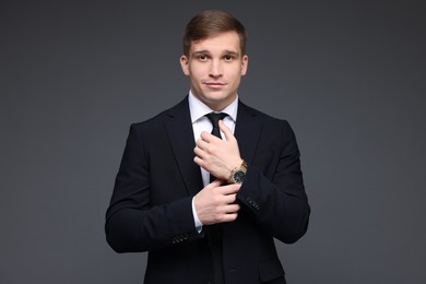 Photo of Man in classic suit with stylish watch on grey background