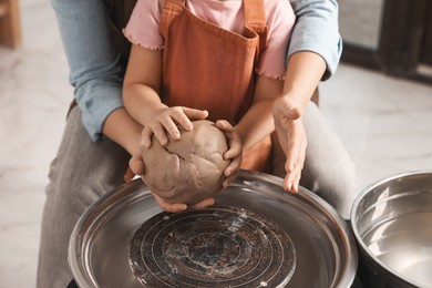 Photo of Hobby and craft. Mother with her daughter making pottery indoors, closeup