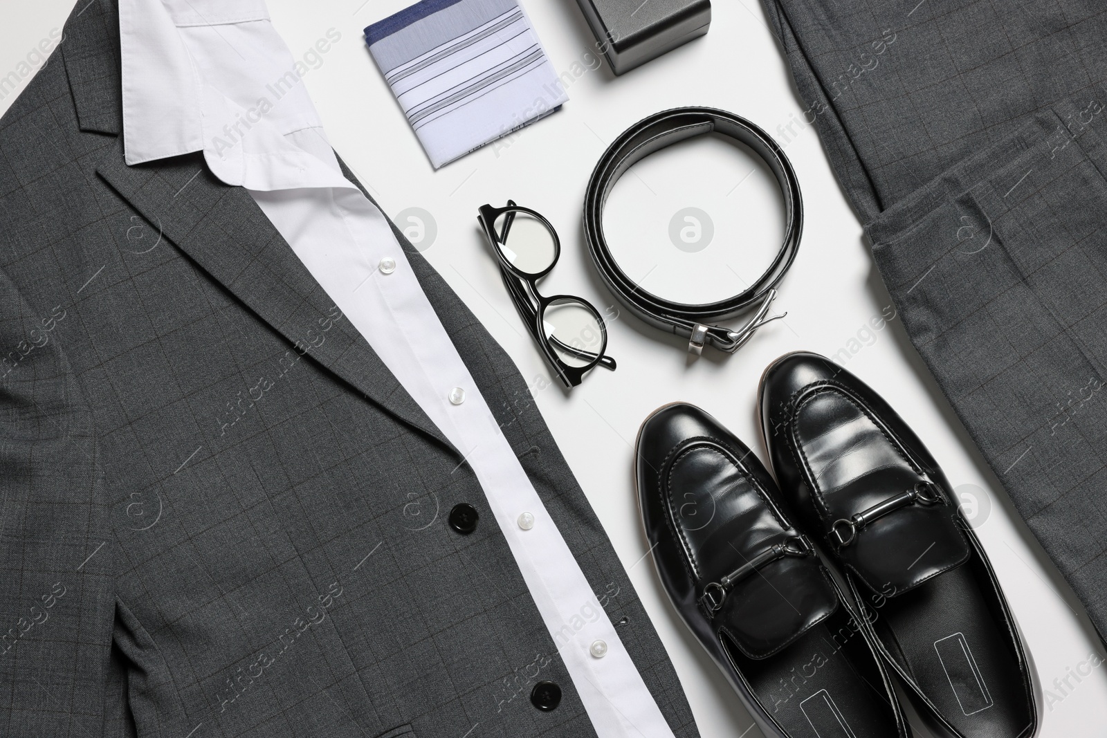 Photo of Elegant men's outfit. Stylish suit, accessories and shoes on white background, flat lay