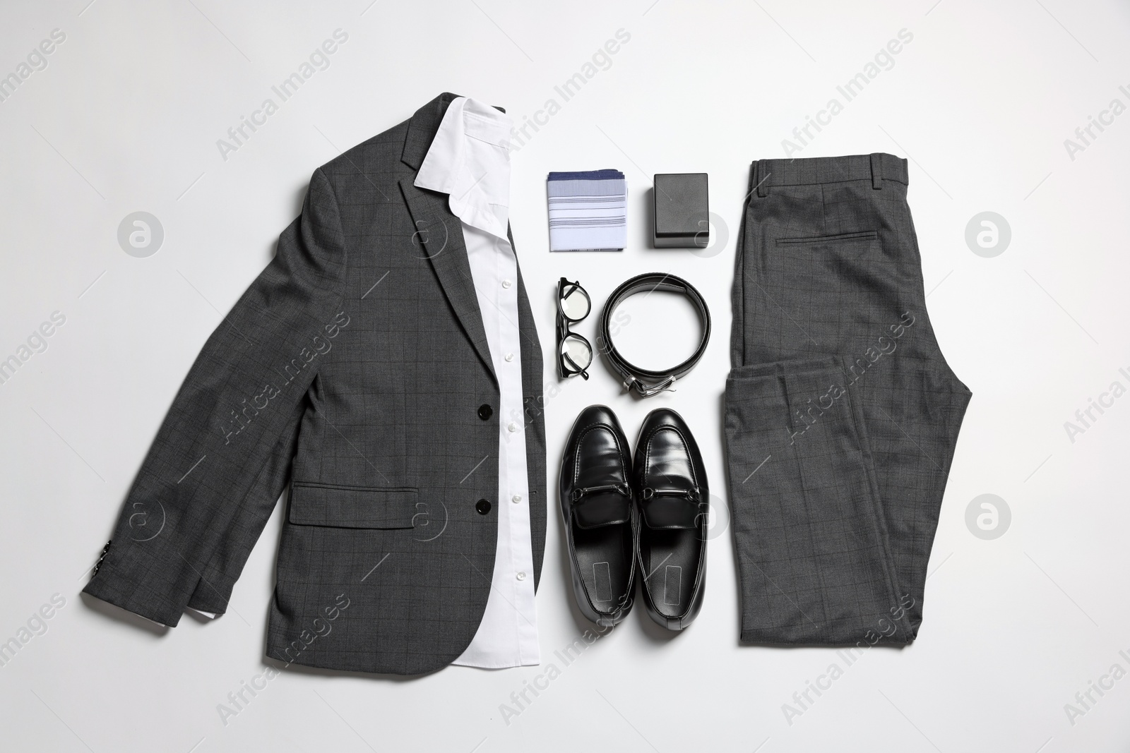 Photo of Elegant men's outfit. Stylish suit, accessories and shoes on white background, flat lay