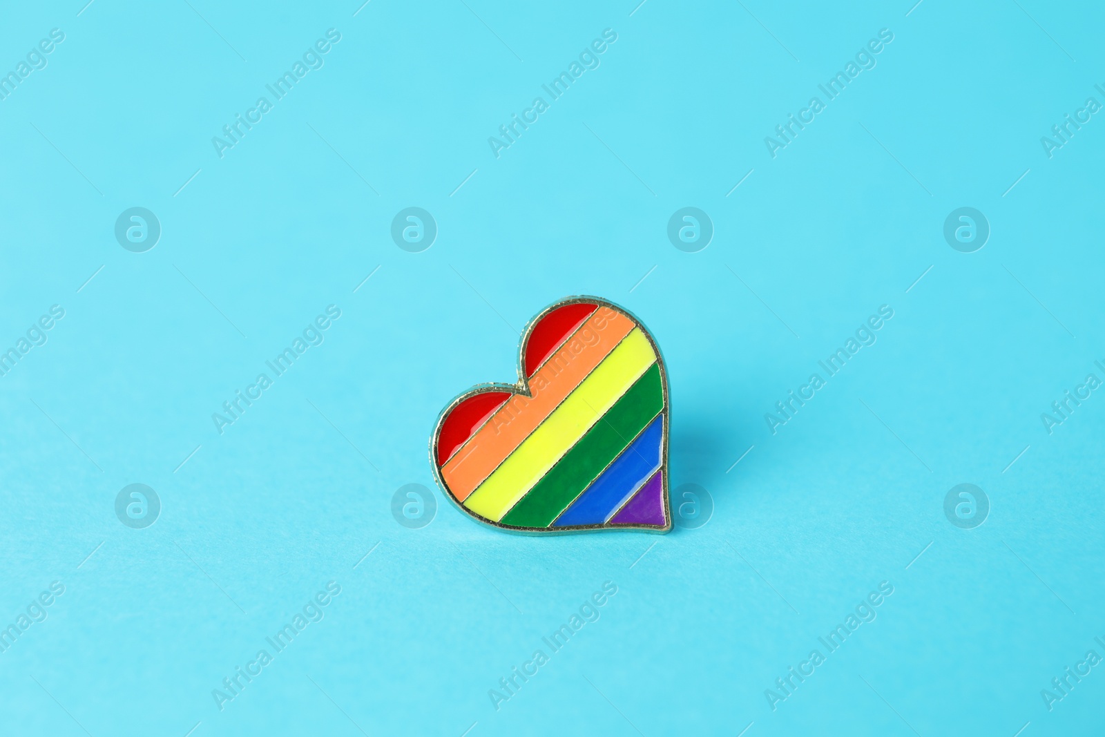 Photo of Heart shaped badge in LGBT colors on light blue background