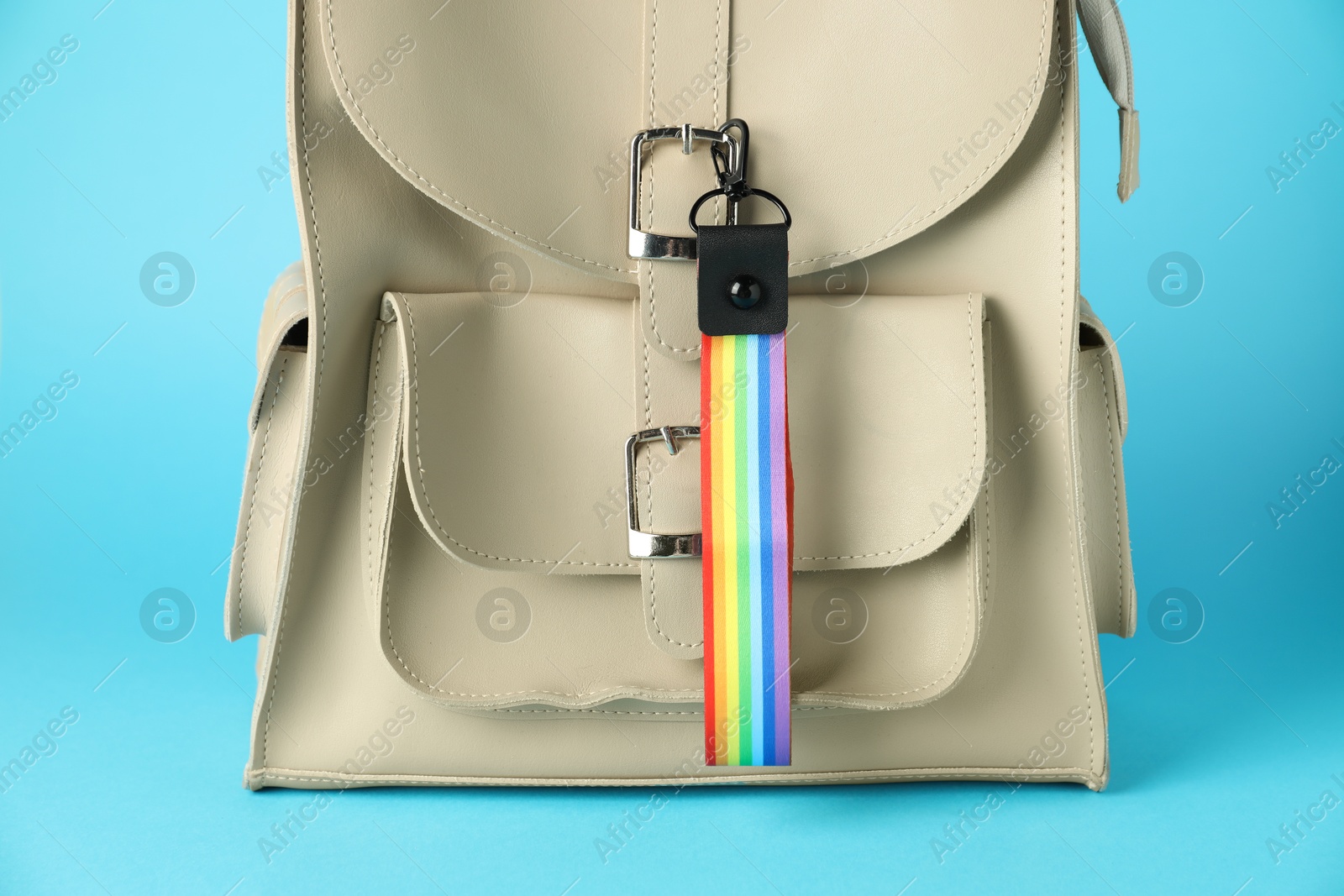 Photo of Backpack with keychain in LGBT colors on light blue background