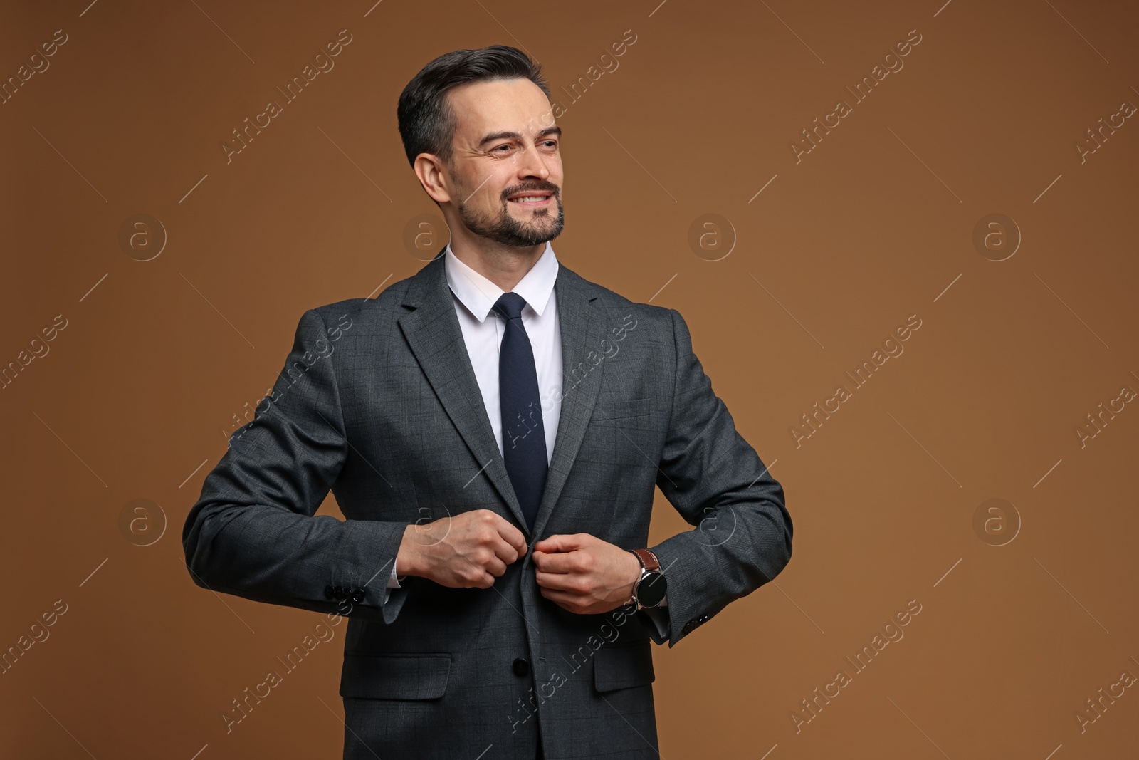 Photo of Man in classic suit on brown background. Space for text