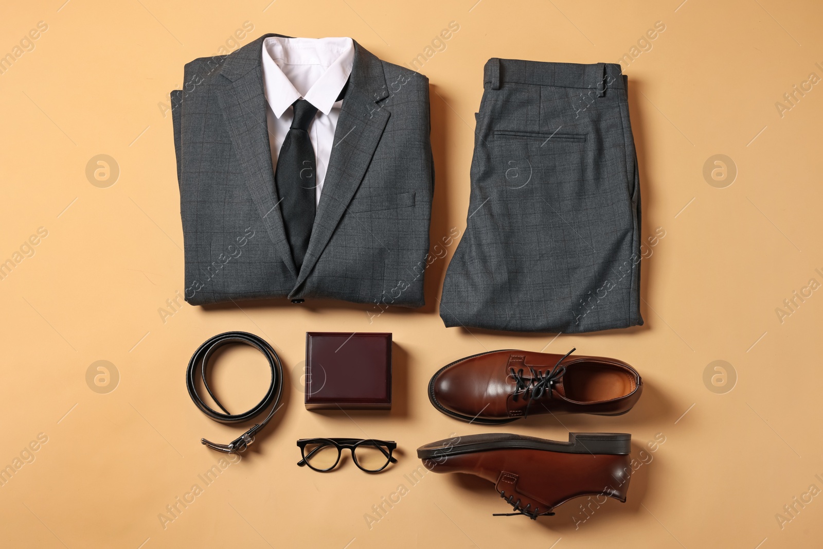 Photo of Elegant men's outfit. Stylish suit, accessories and shoes on beige background, flat lay