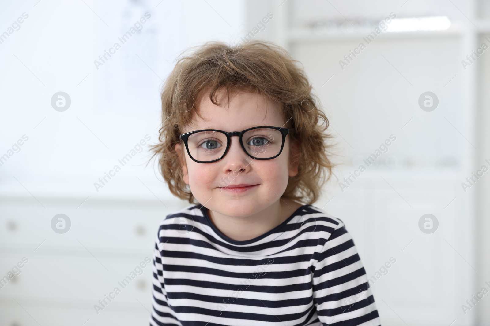 Photo of Little boy wearing glasses at ophthalmologist office