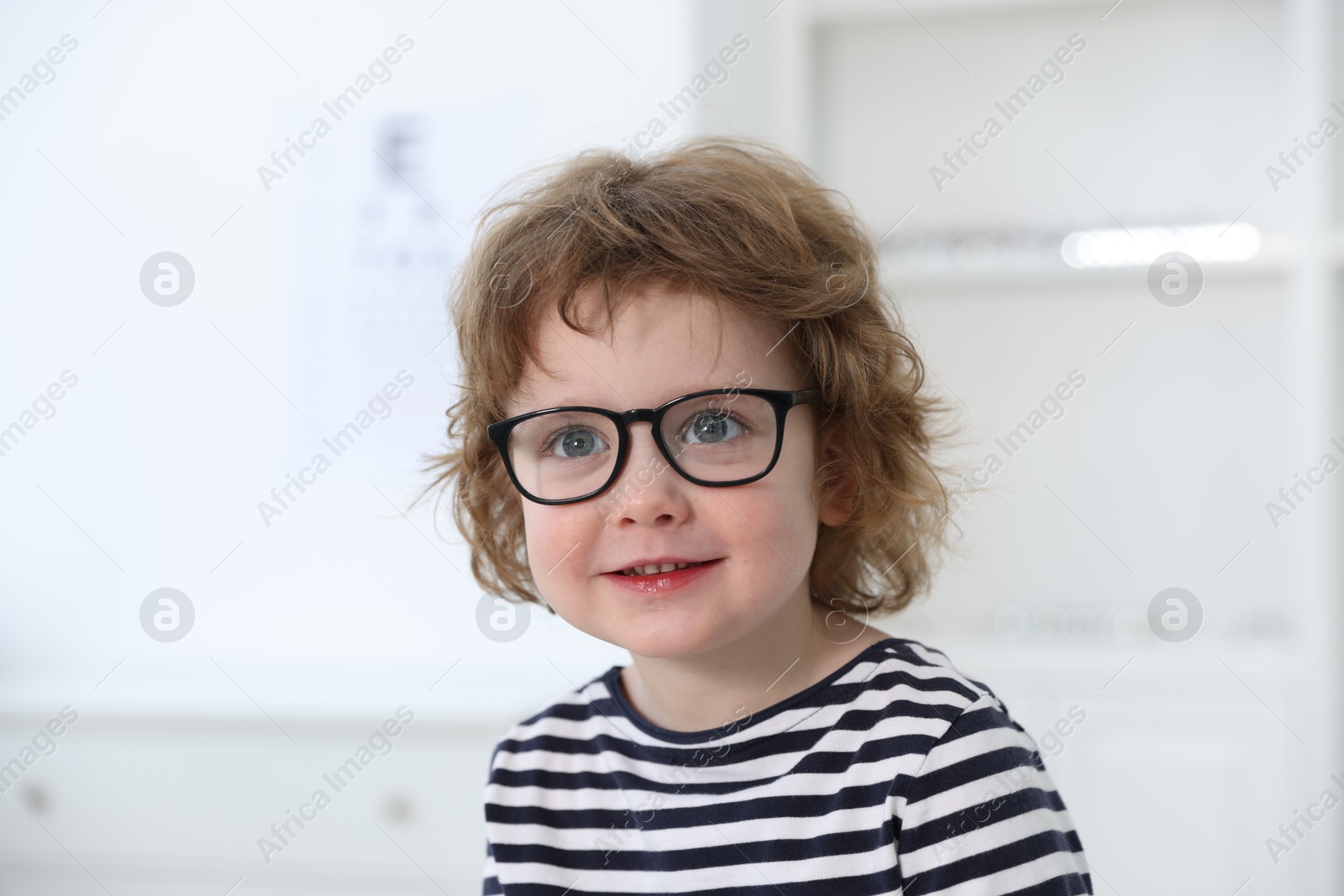 Photo of Little boy wearing glasses at ophthalmologist office