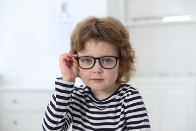 Photo of Little boy wearing glasses at ophthalmologist office