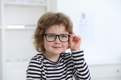 Photo of Little boy wearing glasses at ophthalmologist office