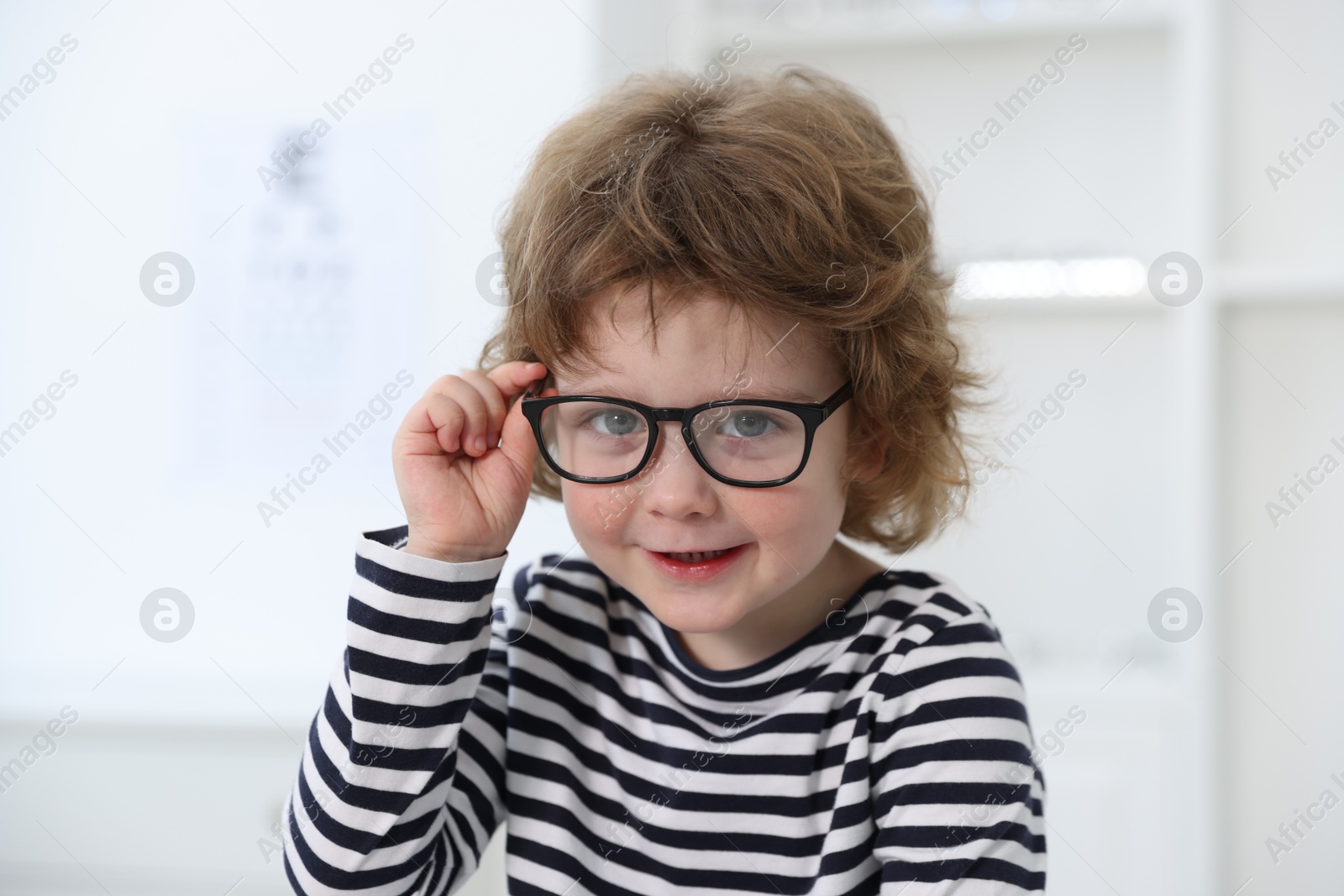 Photo of Little boy wearing glasses at ophthalmologist office