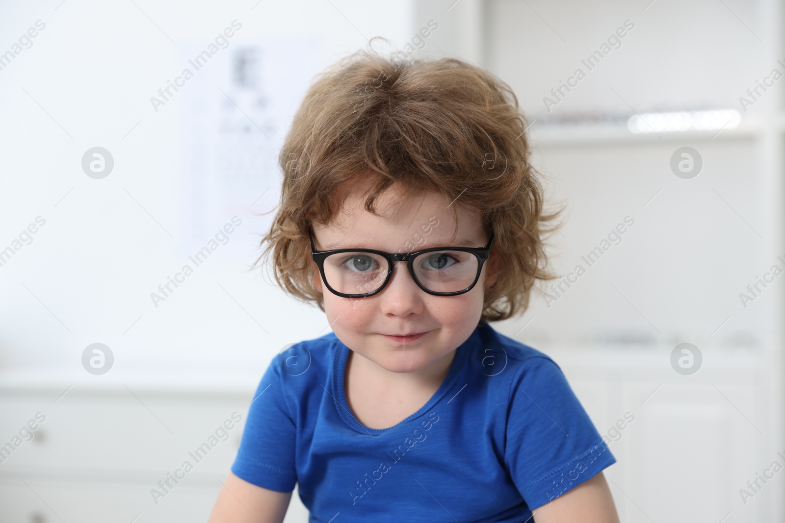 Photo of Little boy wearing glasses at ophthalmologist office