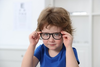 Photo of Little boy wearing glasses at ophthalmologist office