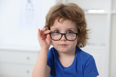 Photo of Little boy wearing glasses at ophthalmologist office