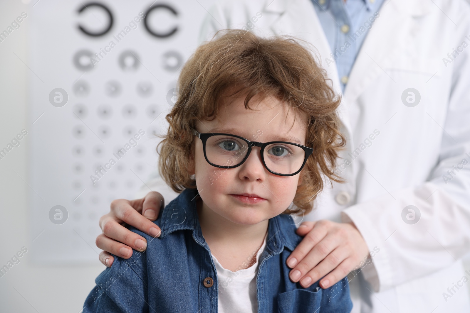 Photo of Little boy with glasses and ophthalmologist in office