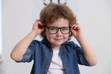 Photo of Little boy wearing glasses at ophthalmologist office