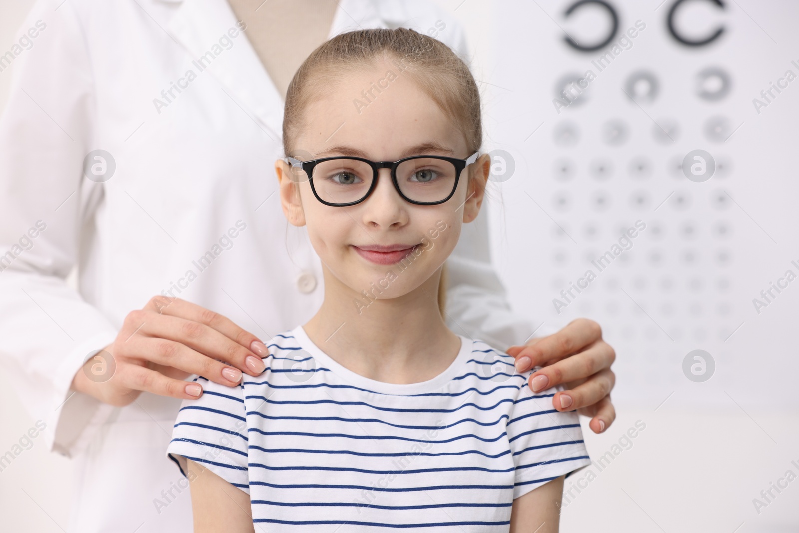 Photo of Little girl with glasses and ophthalmologist in office