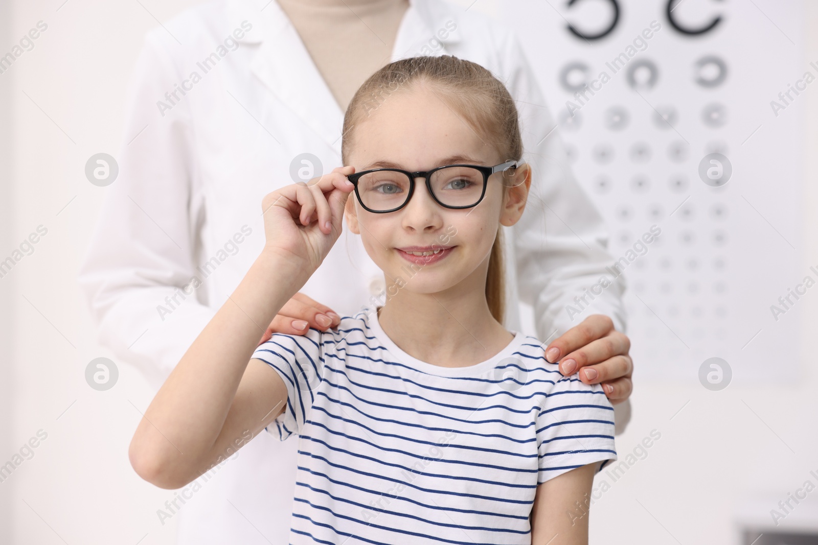 Photo of Little girl with glasses and ophthalmologist in office