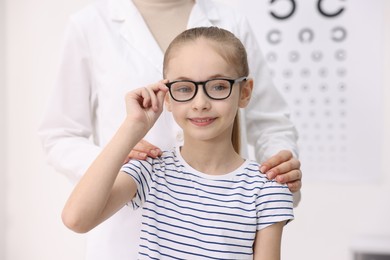 Photo of Little girl with glasses and ophthalmologist in office