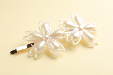 Photo of Beautiful hair clip on beige background, closeup